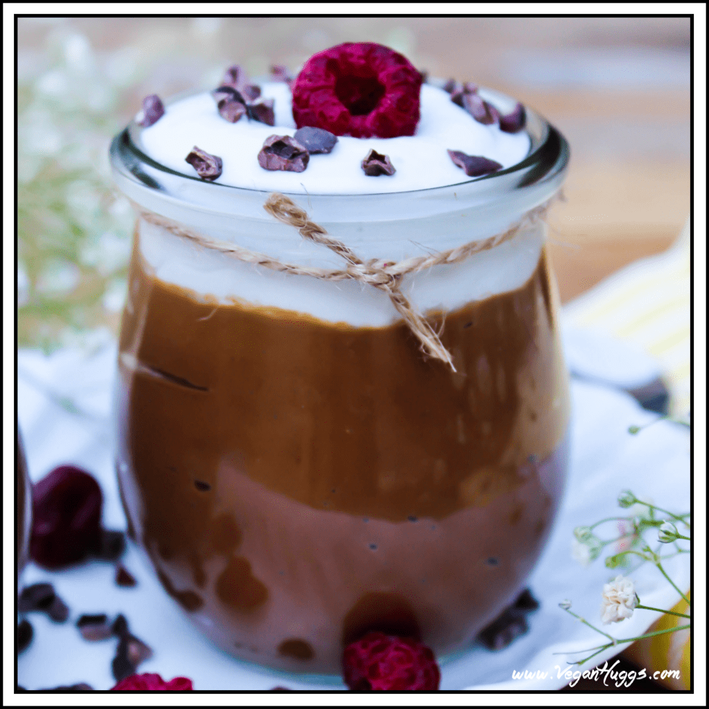 Close up view of avocado mousse in a glass jar and topped with coconut whipped cream.