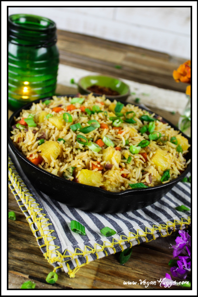 This Easy Pineapple Fried Rice is sweet, savory & tangy. It's a healthier alternative to takeout because it's lower in sodium, vegan & gluten-free. Side view of Easy Pineapple Fried Rice in a cast iron skillet.
