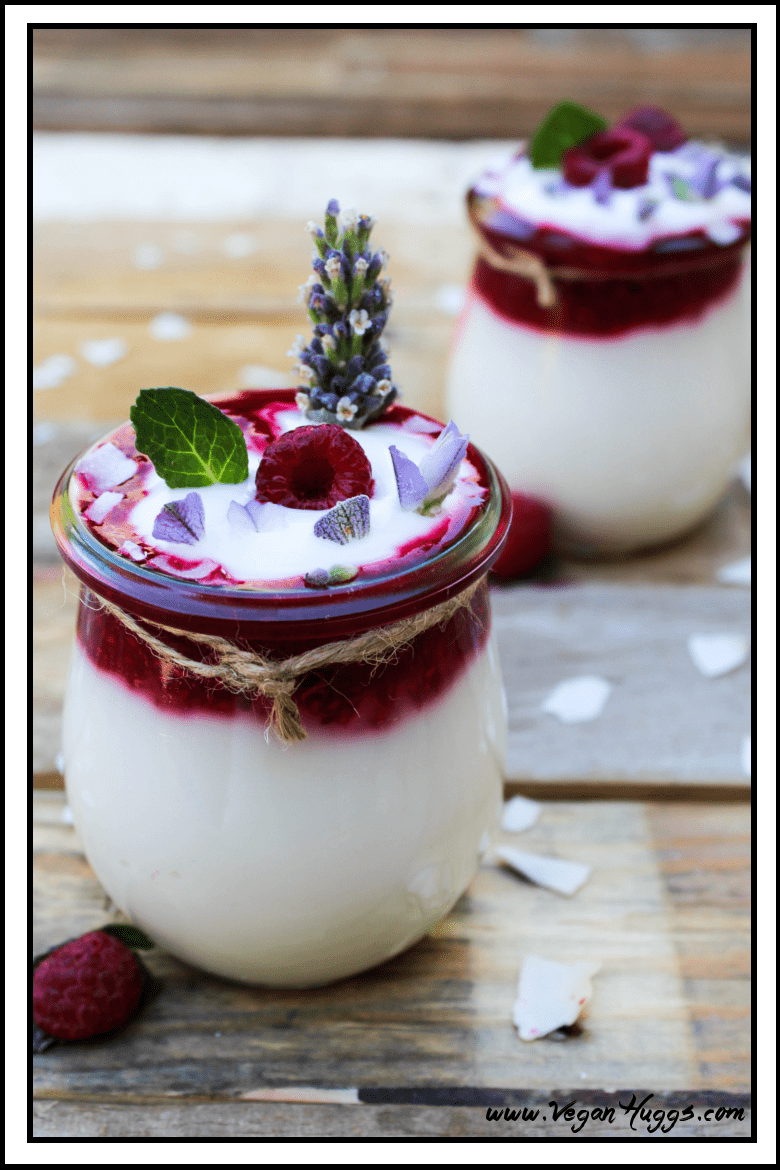 two jars of vegan coconut yogurt on a wooden table. Coconut flakes on the side. 