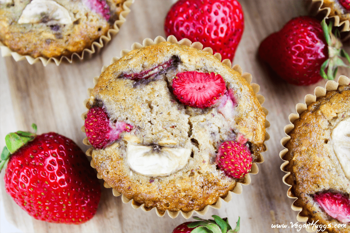 Overhead view of strawberry muffins on a cutting board. 