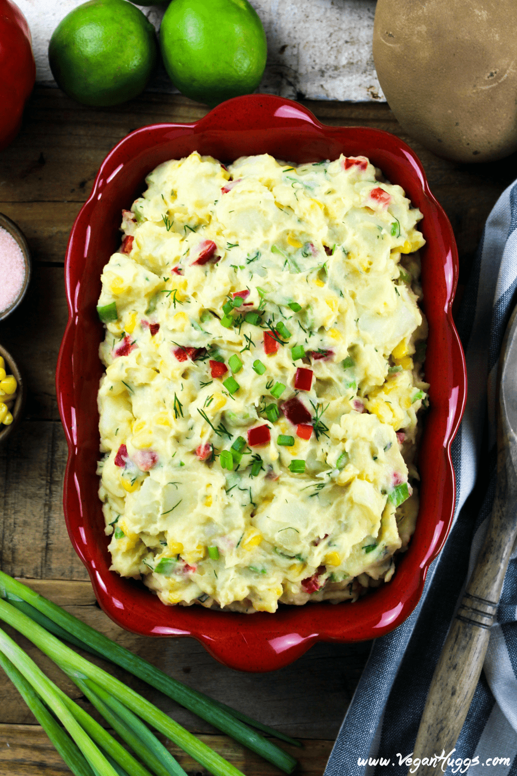 Overhead view of vegan potato salad in a res serving dish with fresh vegetable on the side. 