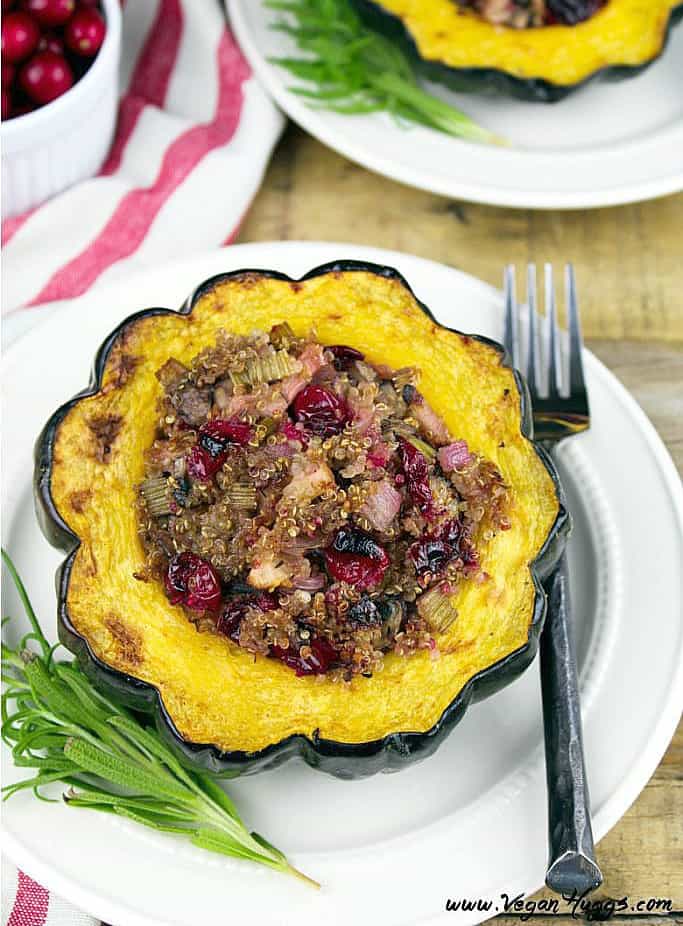 stuffed acorn squash on a white plate. Rosemary and fork on the side. 