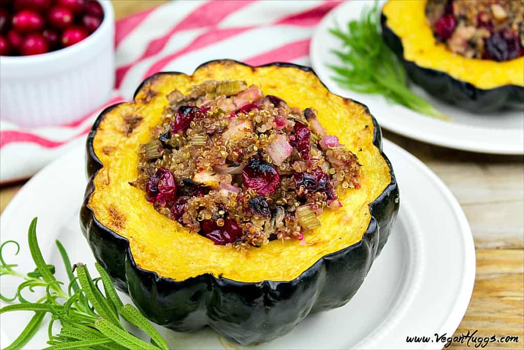 stuffed acorn squash on white plate. Rosemary on the side.