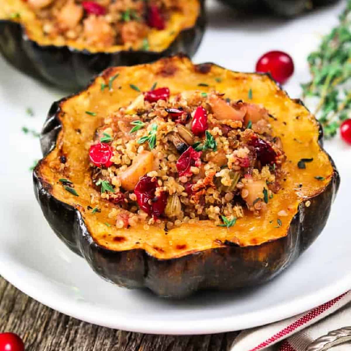 Fully baked stuffed acorn squash on a white serving dish. 