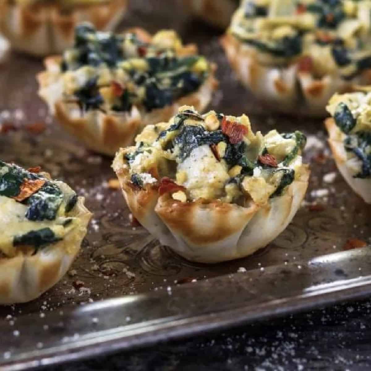 spinach artichoke cups on a silver platter. 