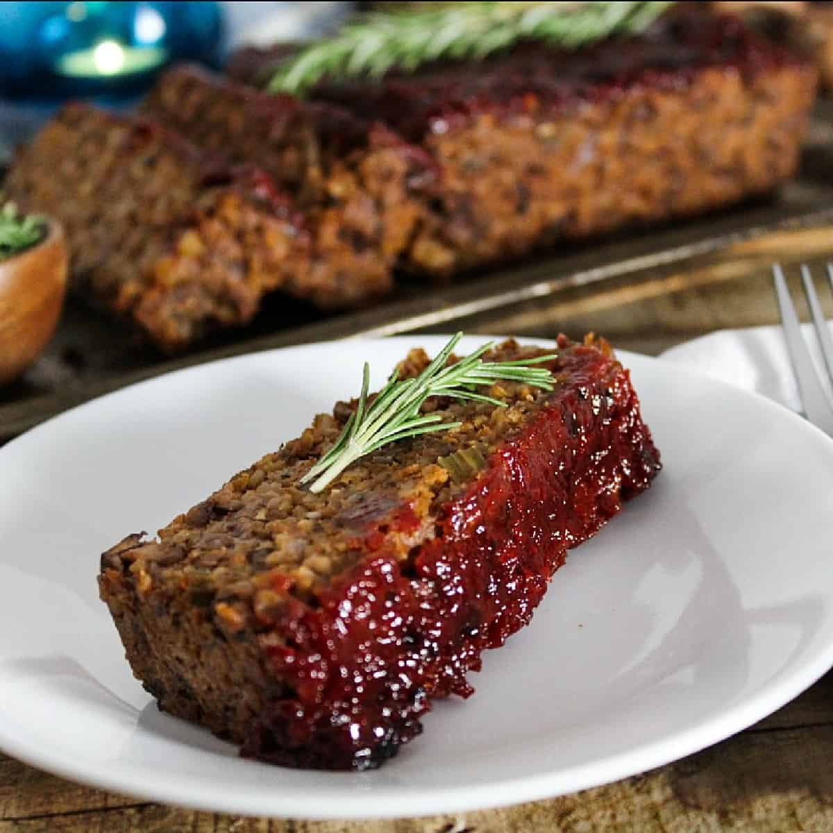 Slice of vegan meatloaf on a white plate. 