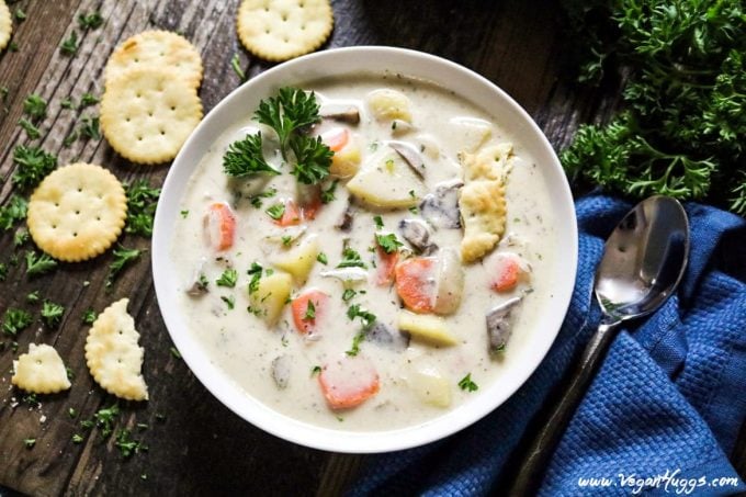 Bowl of Vegan Clam Chowder with crackers and parsley on the side. 