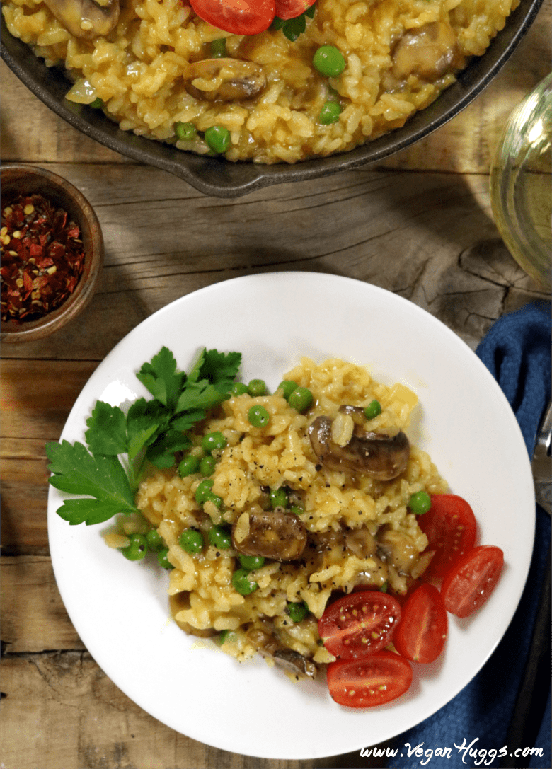 Risotto on a white plate with a skillet on the side. 