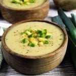 Horizontal photo of two bowls of vegan potato leek soup.