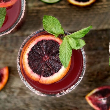 overhead view of a blood orange margarita toped with mint.