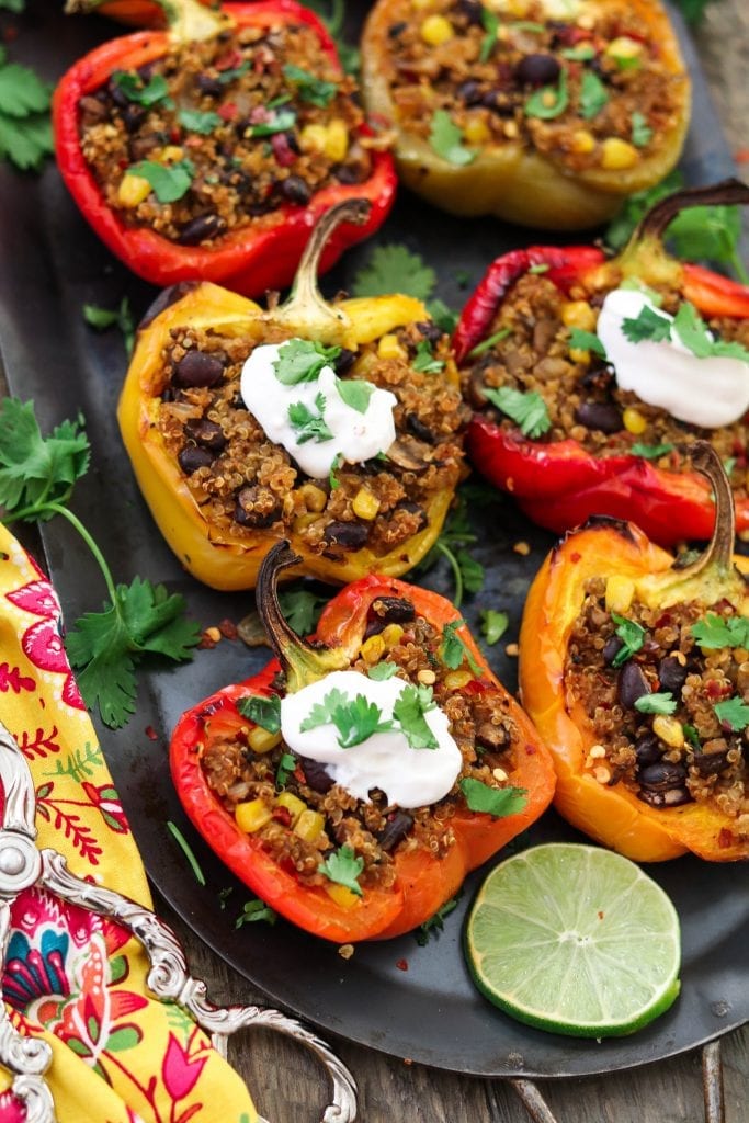 six stuffed peppers on a platter.