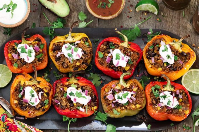 8 Quinoa Stuffed Peppers topped with sour cream, red onion and cilantro.