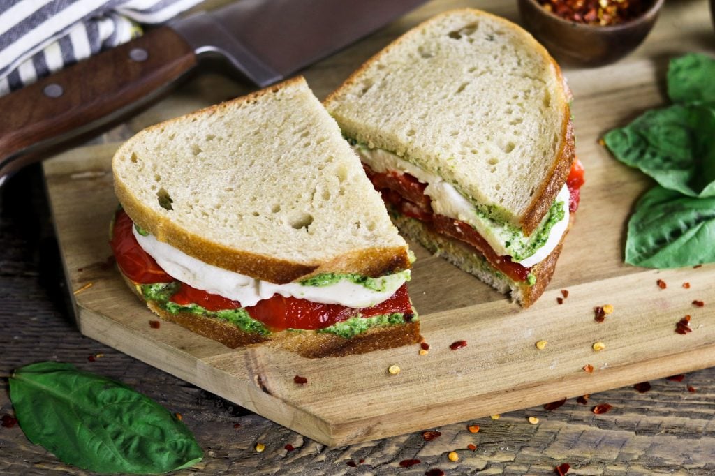 This Roasted Red Pepper Sandwich is built with three layers of deliciousness...creamy vegan mozzarella, cheesy pesto & smoky-sweet peppers.