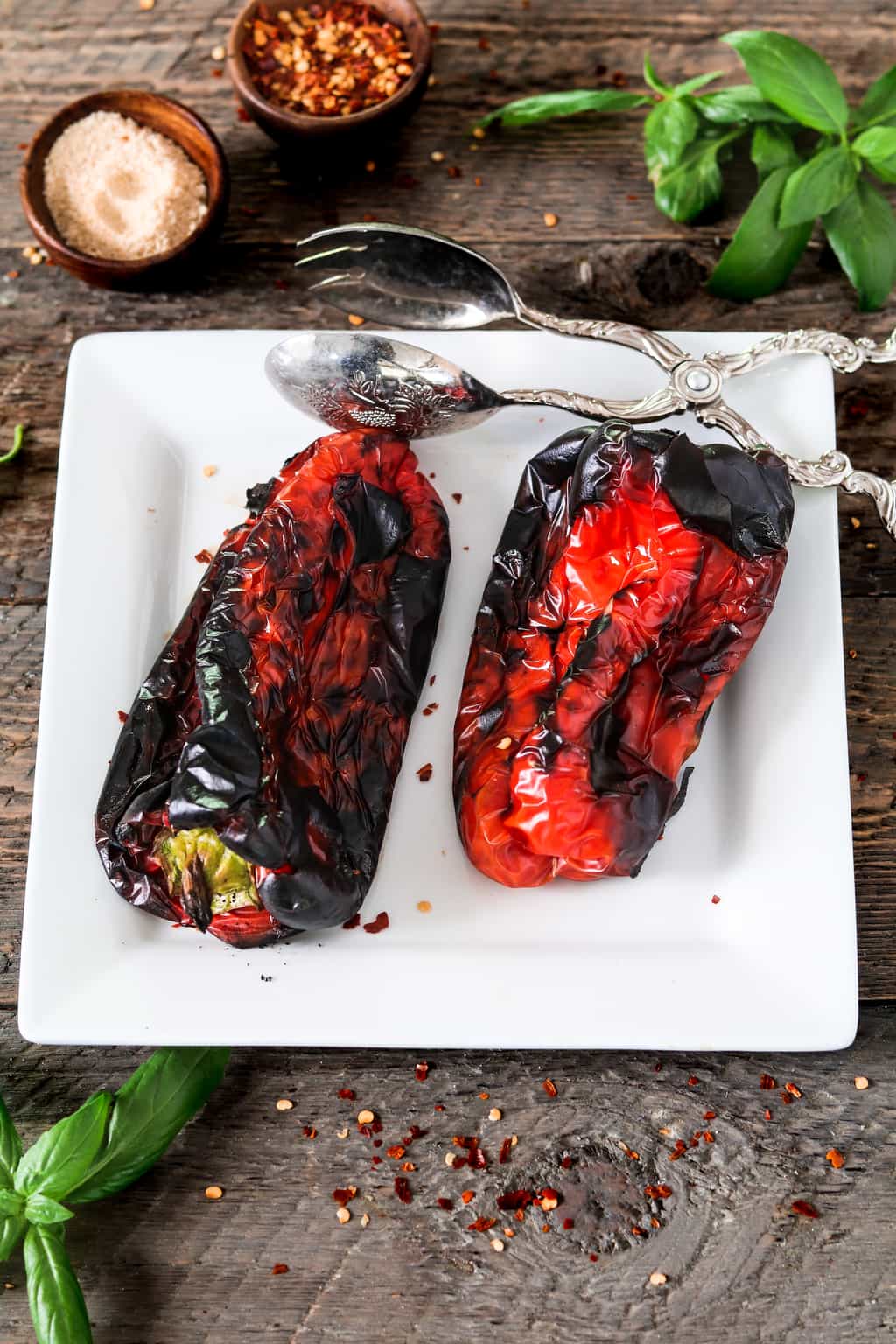 Two roasted red peppers on a white dish