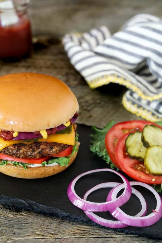 Closeup photo of Bean and Mushroom Burger with catsup in the back. 