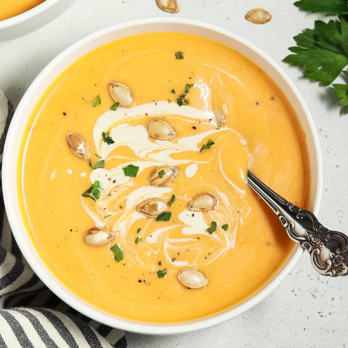 Bowl of butternut squash soup on a table. 