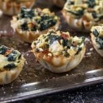 Vegan Spinach Artichoke cups in phyloo shells on a tray.