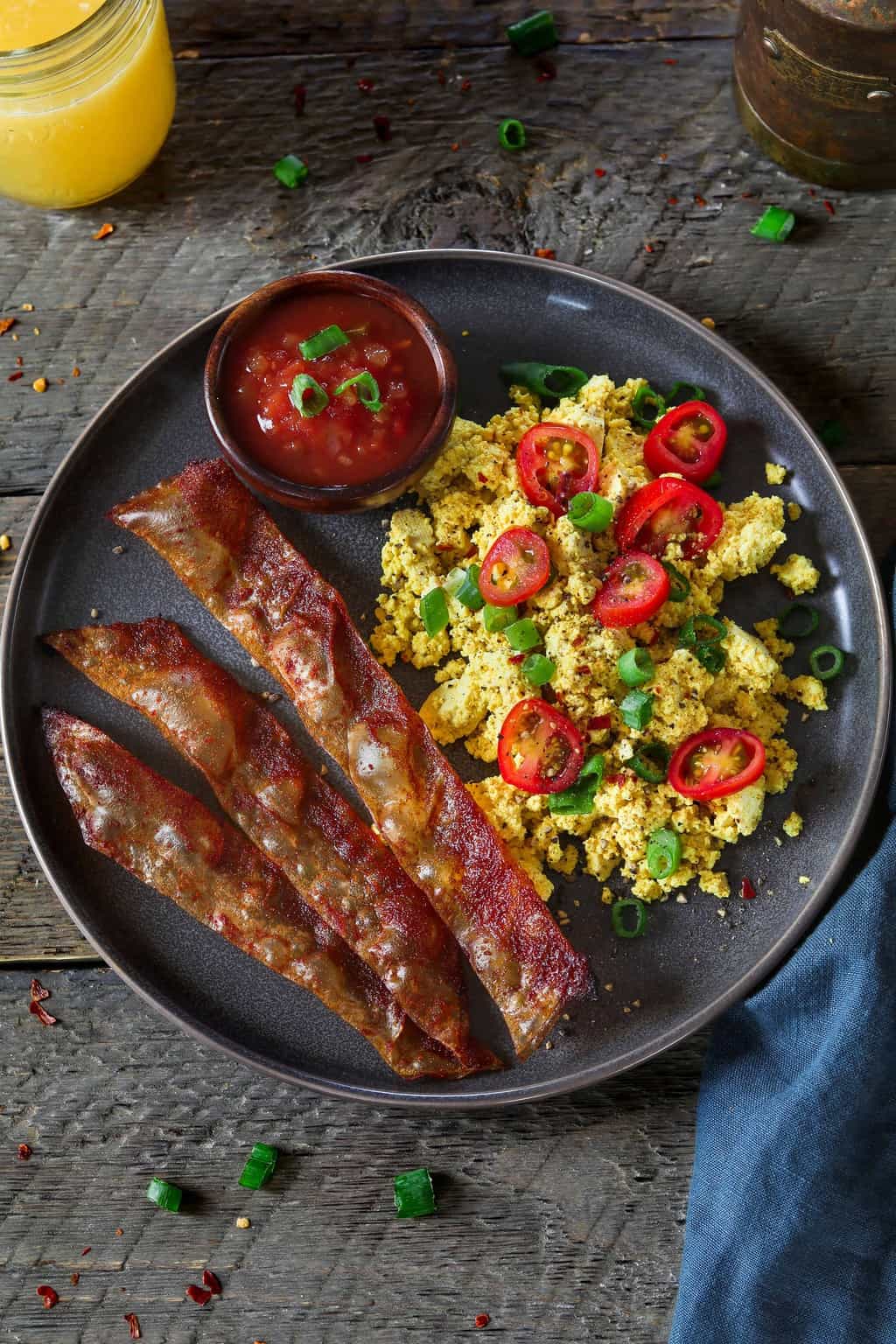 Rice Paper Vegan Bacon with tofu scramble on a grey plate.