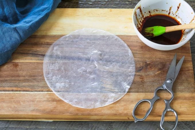 Wet rice paper sheets on cutting board.