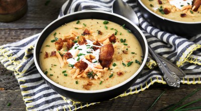 Horizontal photo of two bowls of vegan baked potato soup