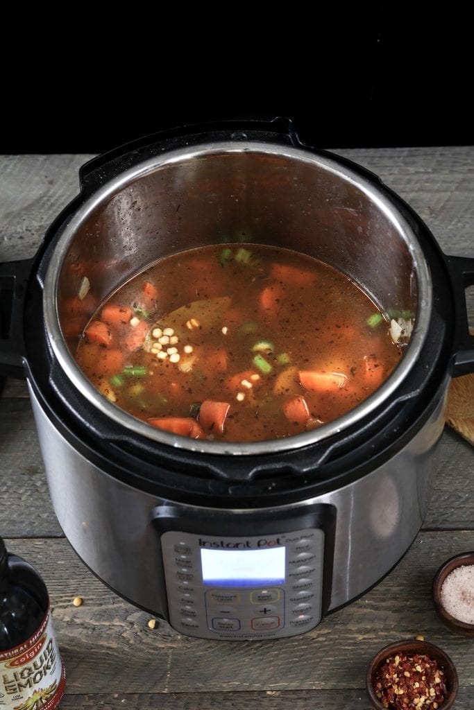 Adding broth to the Instant Pot to make yellow split pea soup. 