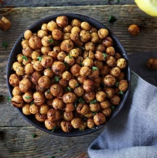 Air Fried Chickpeas in a black bowl. Lemon and paprika on the side.
