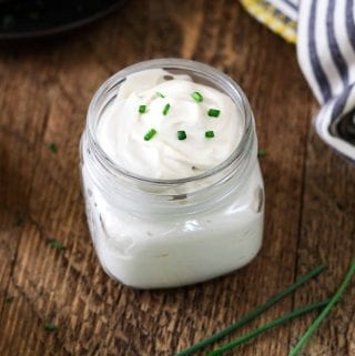 vegan sour cream in a glass jar. Topped with chives.