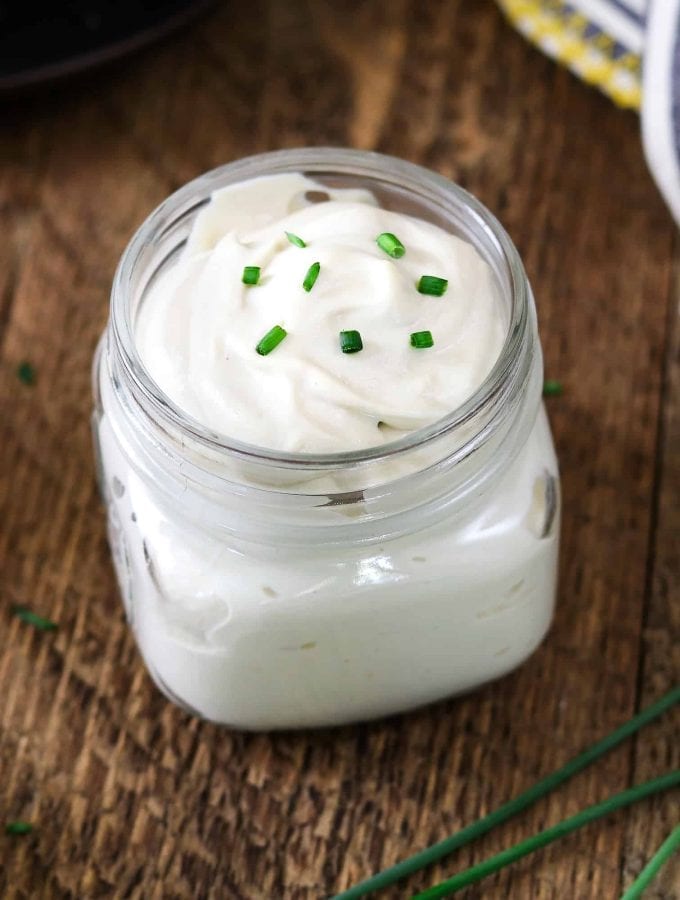 vegan sour cream in a glass jar. Topped with chives.