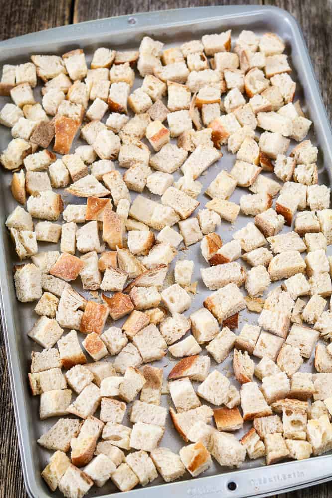 Silver baking tray of toasted bread cubes for Vegan Sourdough Bread Stuffing.
