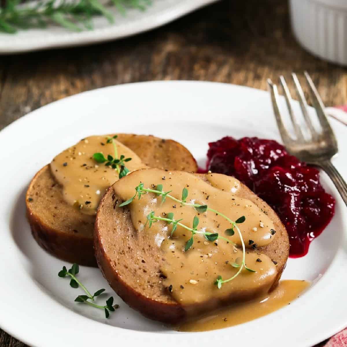 two slices of vegan holiday roast on a white plate. 