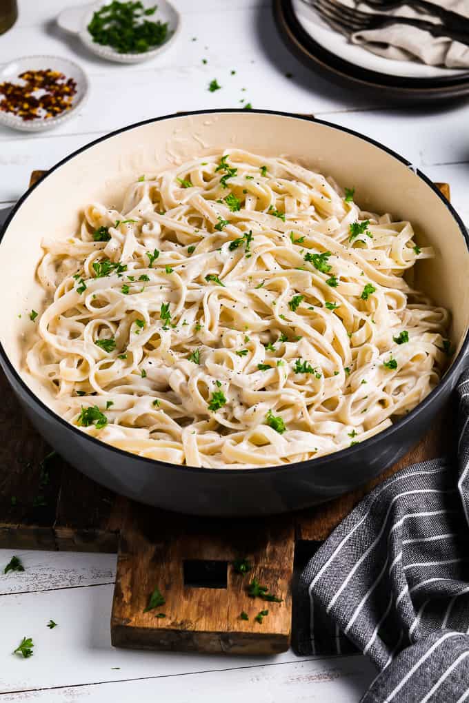 a pan of pasta topped with fresh parsley. 