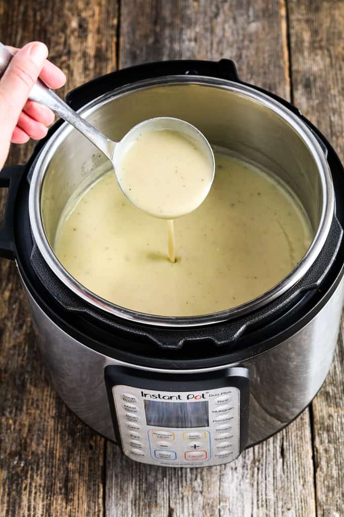 Ladle filled with vegan potato leek soup. 