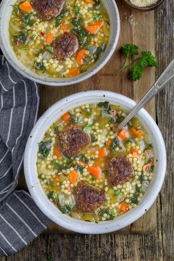 overhead view of two white bowls filled with vegan italian wedding soup. 