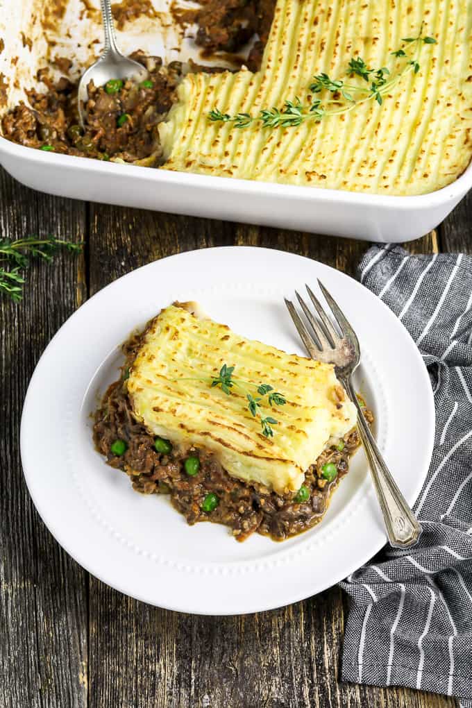 Piece of vegan shepherd's pie on a white plate with a fork on the side. 