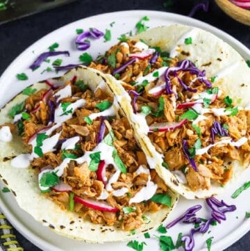 two jackfruit tacos on a white plate.