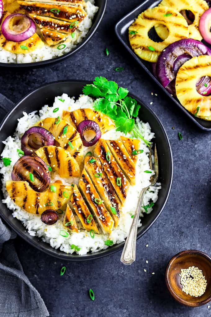 overhead view of a teriyaki bowl with grilled pineapple and onions on the side. 