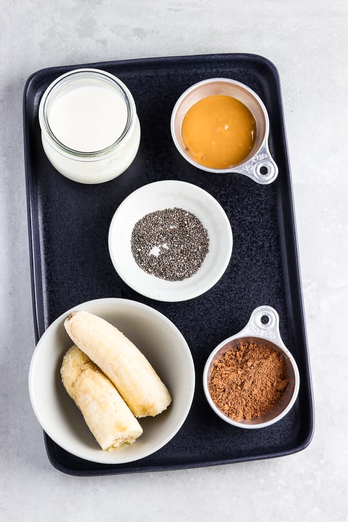 Ingredients for chunky monkey smoothie on a black serving tray. 