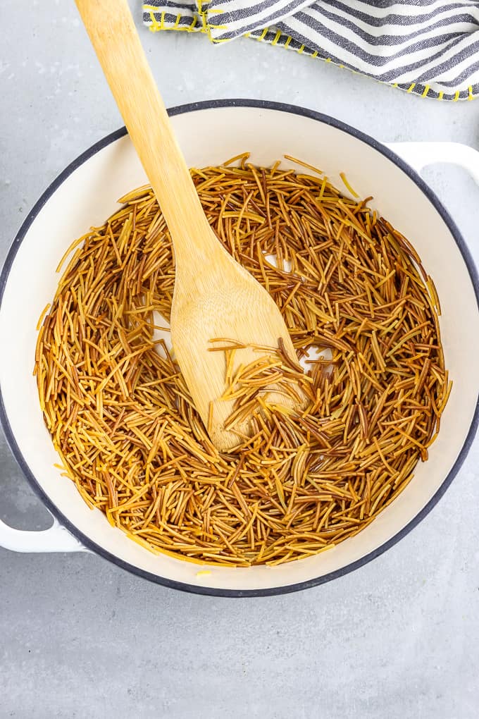 Browned fideo noodles in a large soup pot. 