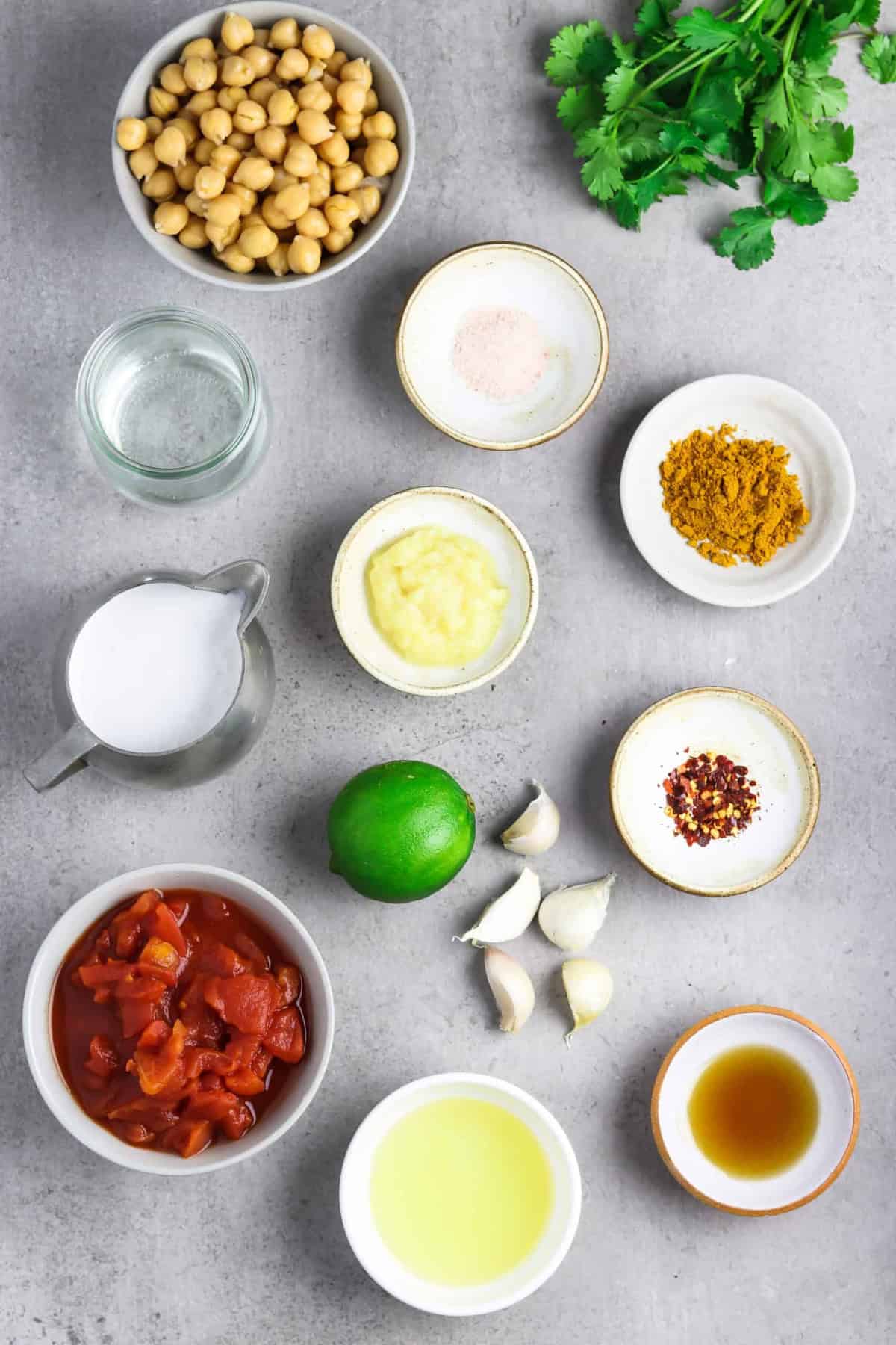 This is the easiest Vegan Chickpea Curry you'll ever make! It calls for pantry staples and it takes 30 minutes on the stove. Plus, it's full of mouth-watering flavor and it's all made in one pan, too! Ingredients to make the recipe on a stone table top.