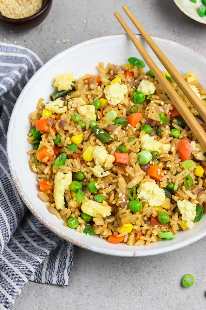 Bowl of vegan fried rice with chopsticks and napkin on the side. 