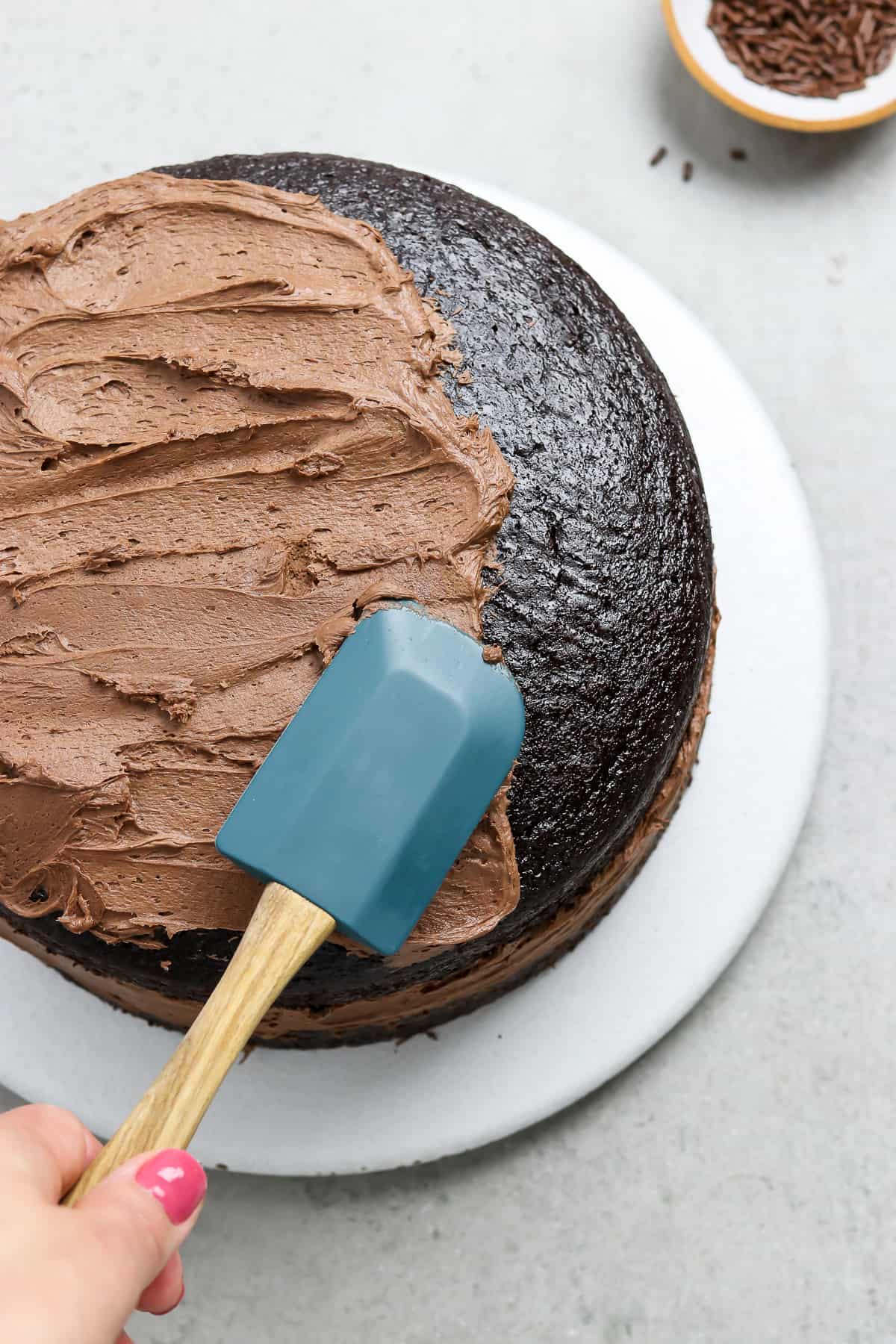 Frosting a cake with a blue spatula