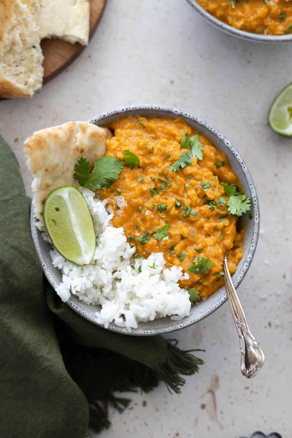 Overhead view of red lentil dahl in a gray bowl. 