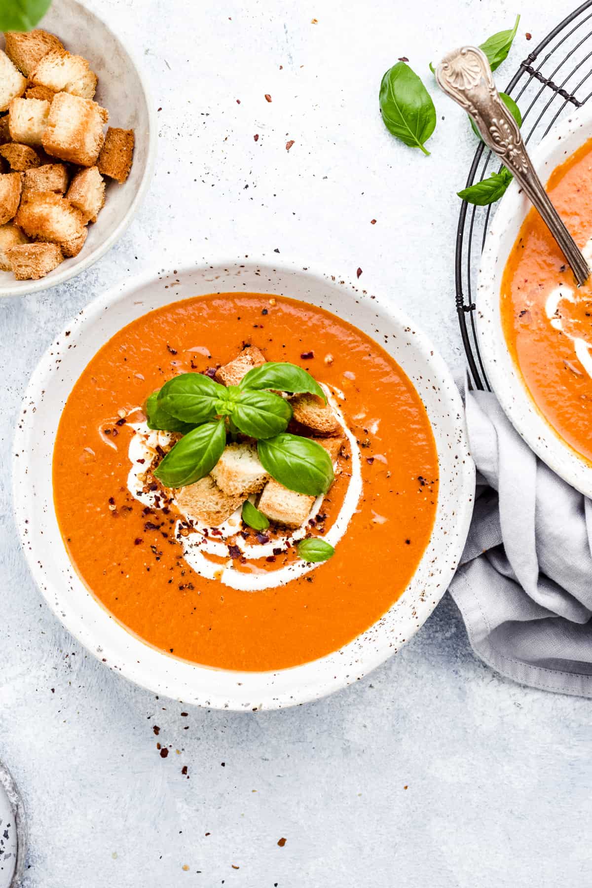 overhead view of two bowls of soup and croutons on the side. 