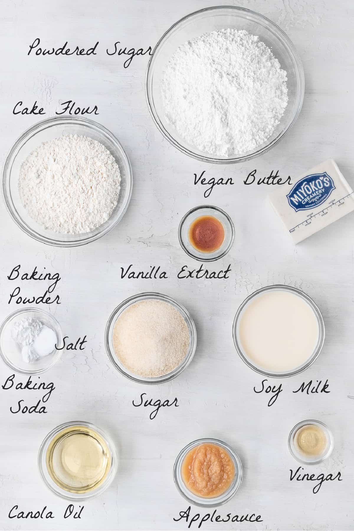 Ingredients to make cupcakes on a white table top. 