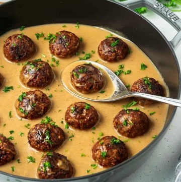 vegan Swedish meatballs in a gray pan filled with gravy
