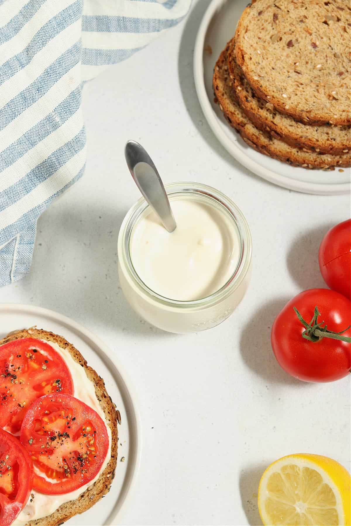 Overhead view of vegan mayo in a jar with sandwich fillings on the side. 