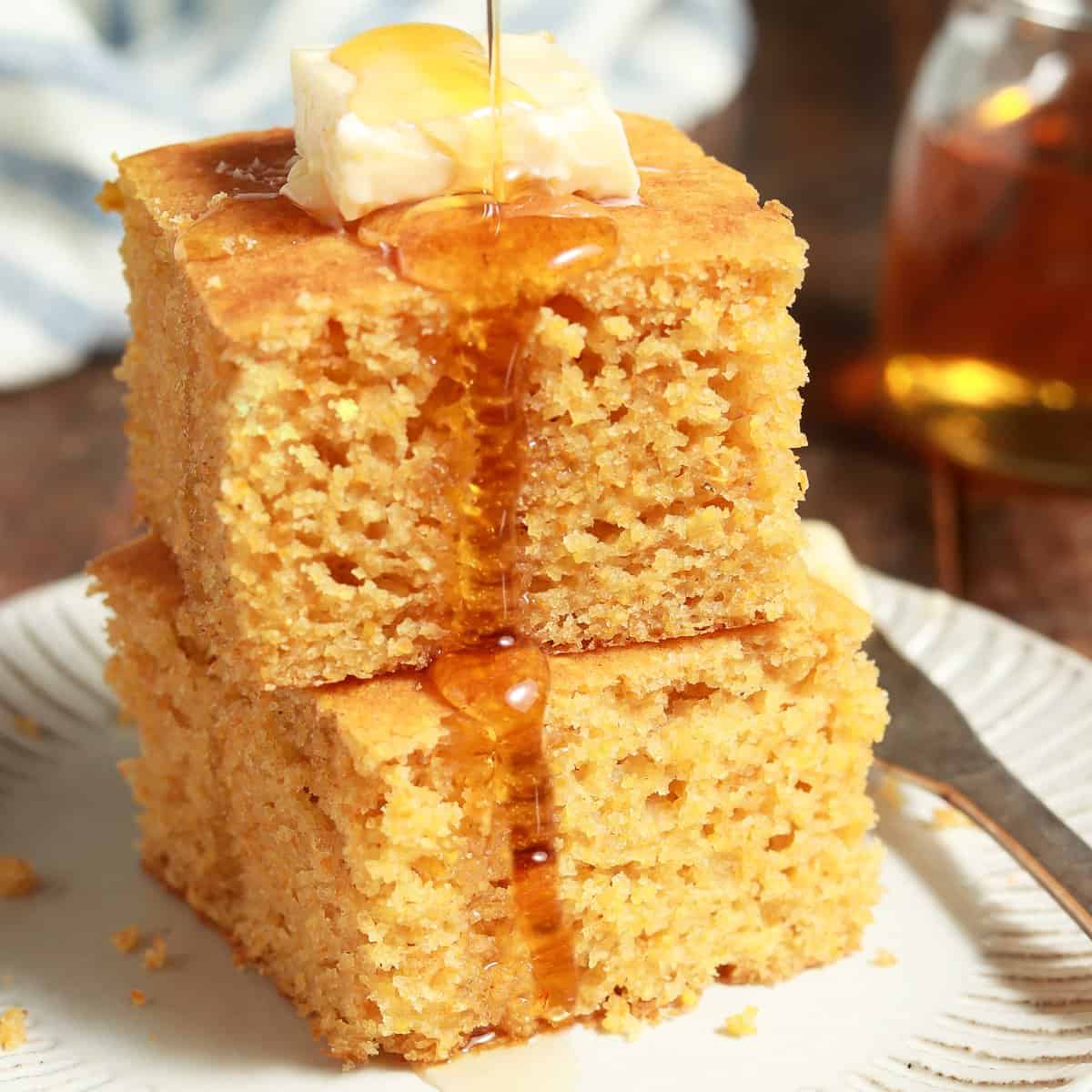 two pieces of vegan cornbread on a white plate