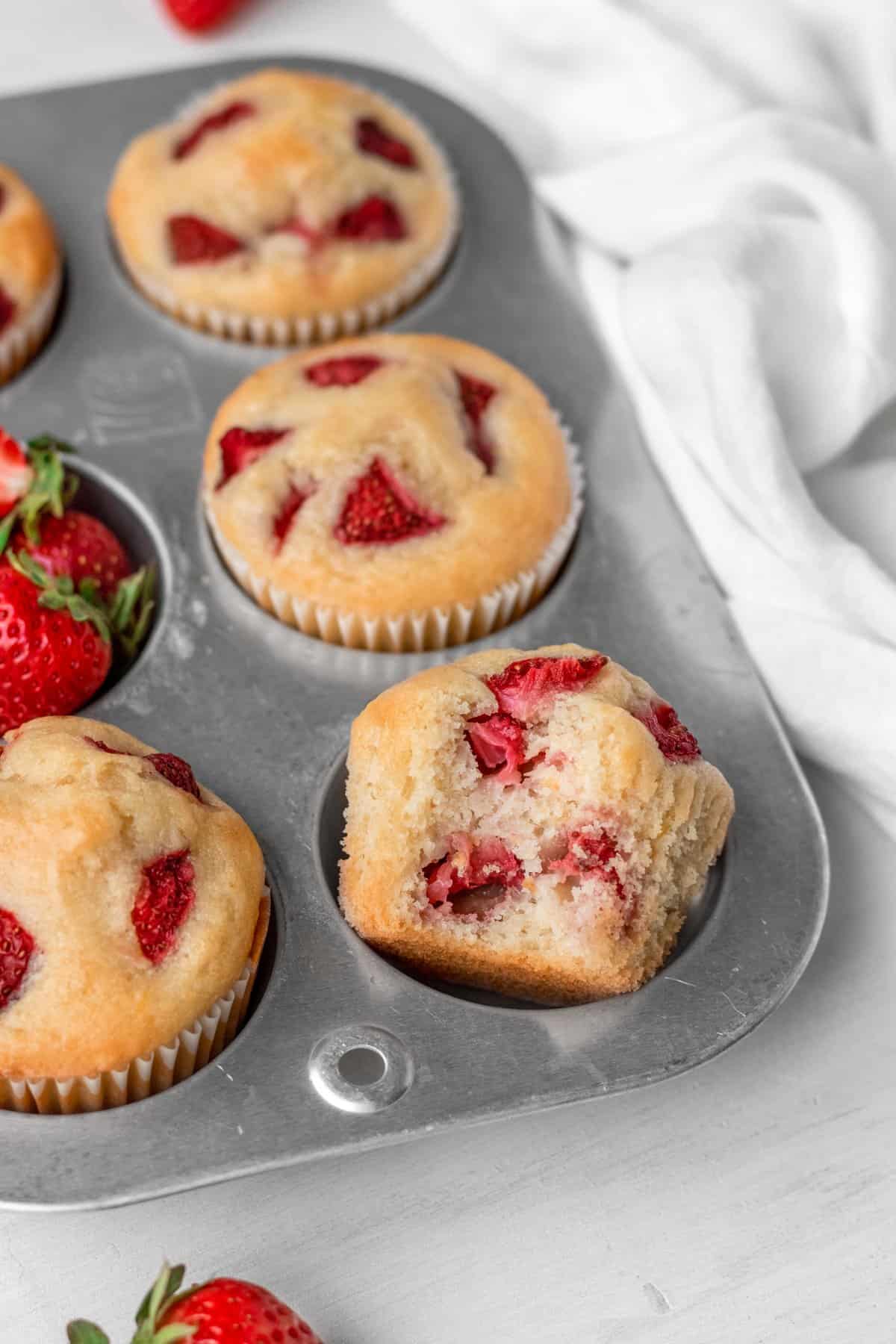 Fully baked vegan strawberry muffins in a muffin tin. 