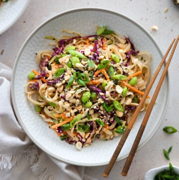 peanut noodle salad in a bowl with chopsticks on the side.