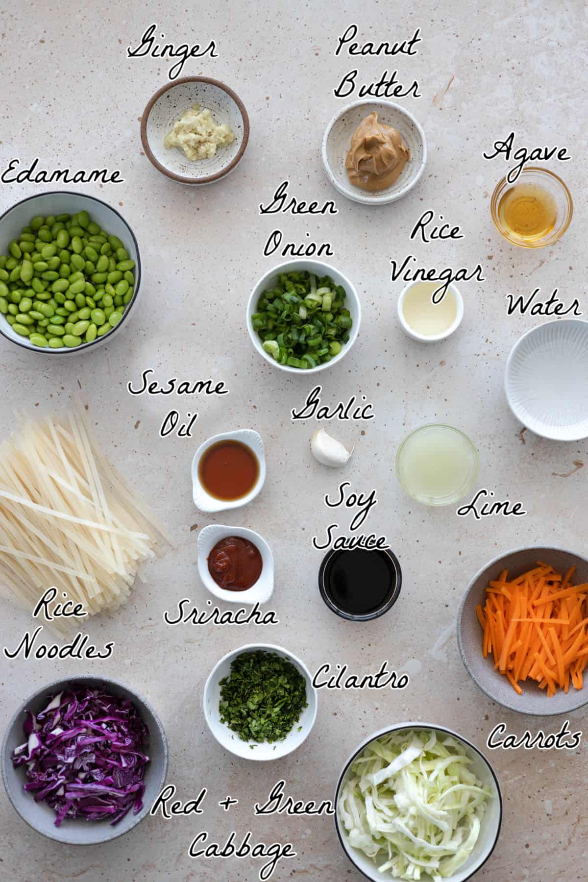 ingredients for noodle salad spread out on a table top. 